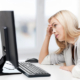Frustrated blonde woman sitting at a computer